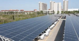 Ombrière panneau solaire au-dessus des places d’un parking, voitures blanches garées sous les panneaux photovoltaïques